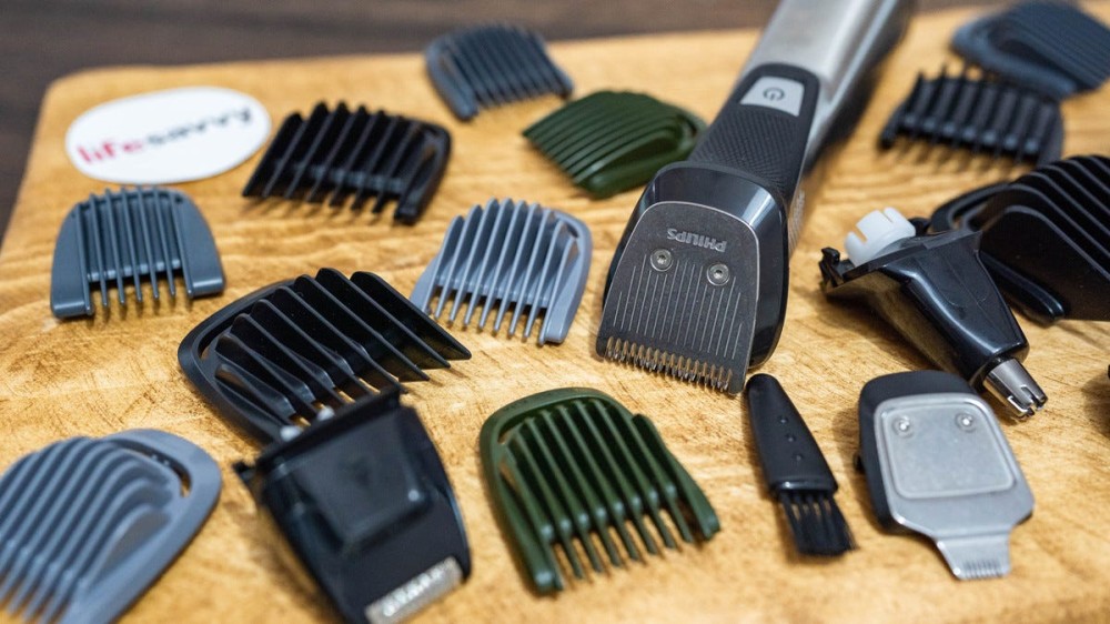 Various hair trimmers and attachments on a wooden surface.